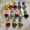 A collection of handcrafted troll doll figurines in various colors and textures arranged on a light surface.