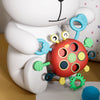 A white silicone pull string sensory toy for babies with colorful rings and textures.