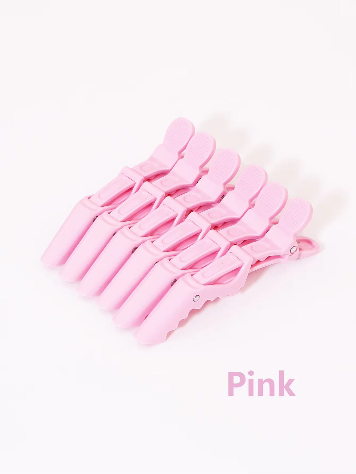 A set of pink alligator hair clips for styling and sectioning.