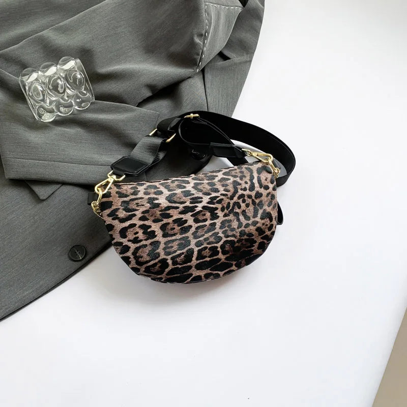 A leopard print waist bag with a black strap is shown resting on a gray blazer.