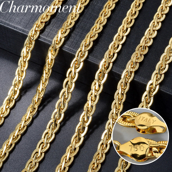 A close-up view of multiple strands of 18k gold-plated Cuban link chain necklaces on a dark background.