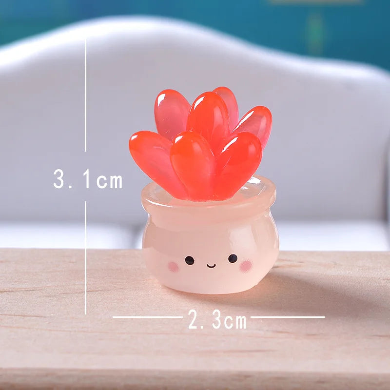 A small, round, translucent pink succulent cactus miniature with bright orange-red leaves, shown next to a measurement scale.