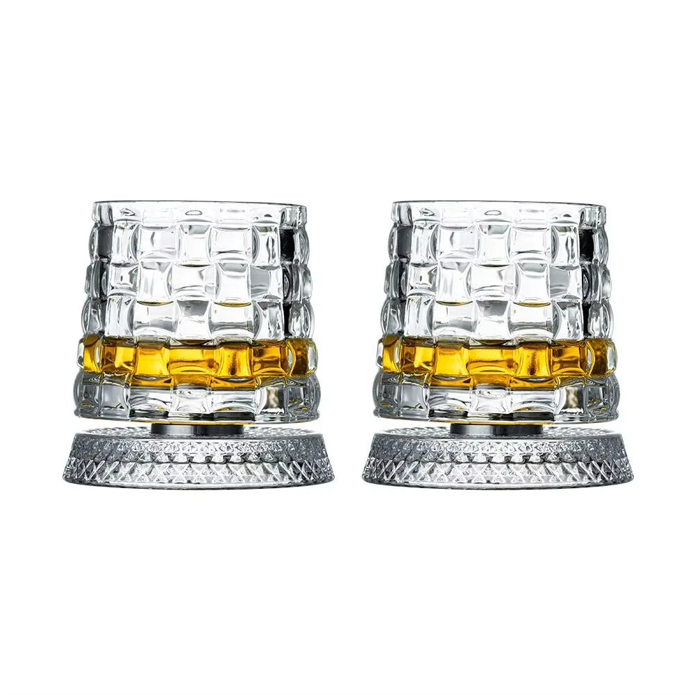 Ein Set aus zwei rotierenden Whiskeygläsern mit bernsteinfarbigem Inhalt und klaren Glasfüßen.