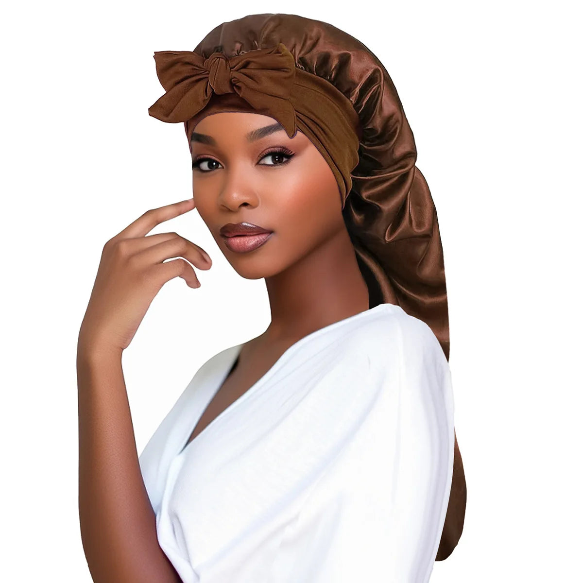 A woman wearing a brown satin sleep bonnet with an adjustable tie and a white top.