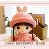 A pink rabbit fairy plush doll with dark hair and a collar, displayed in a woven basket.
