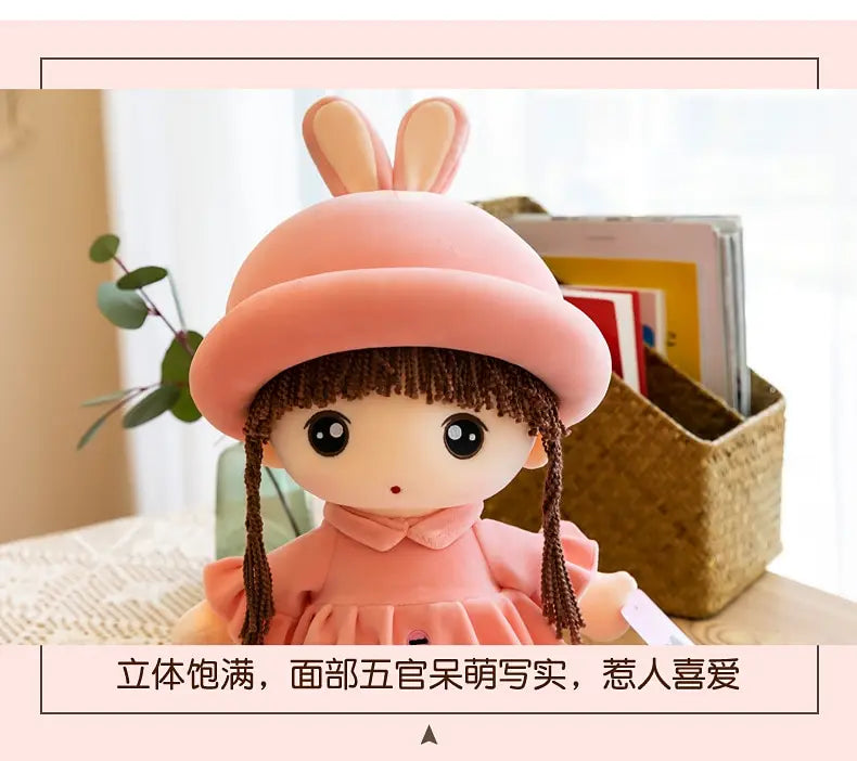 A pink rabbit fairy plush doll with dark hair and a collar, displayed in a woven basket.