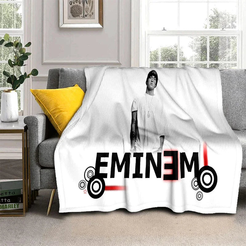 A white throw blanket featuring a portrait of Eminem and text that reads Eminem.