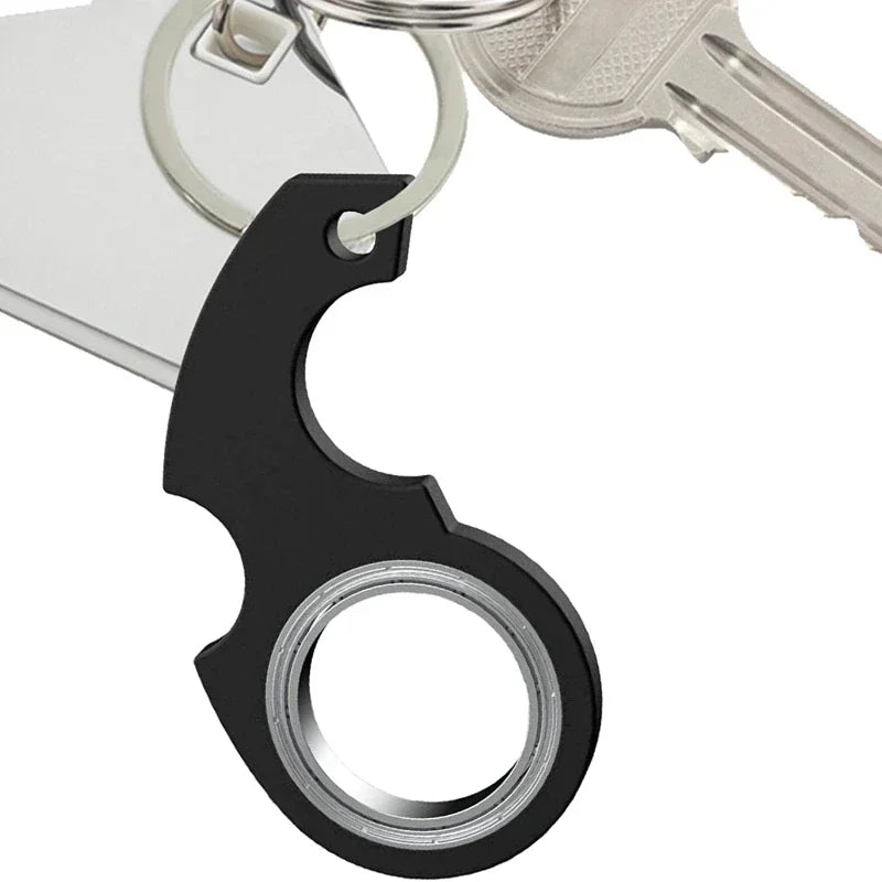 A black metal fidget spinner keychain attached to a silver key ring.