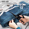 Hands using professional heavy-duty fabric shears to cut multiple layers of denim fabric