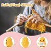 A person is knitting a yellow crocheted animal figurine with an inspirational card.