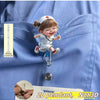 A small doll dressed as a nurse is shown holding a medical instrument, displayed on a blue fabric background.