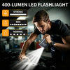 Man using a 400-lumen LED flashlight to check a portable car jump starter.