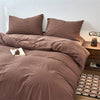 A brown plaid duvet cover with matching pillows on a bed.
