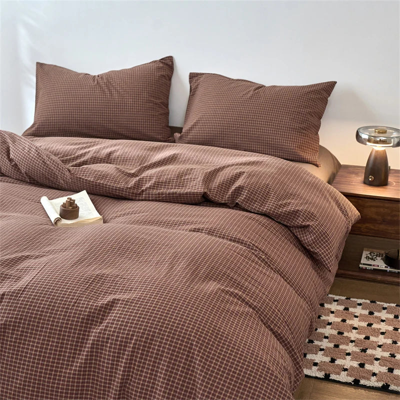 A brown plaid duvet cover with matching pillows on a bed.