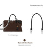 A black synthetic leather handbag with a silver buckle and a long strap is shown.