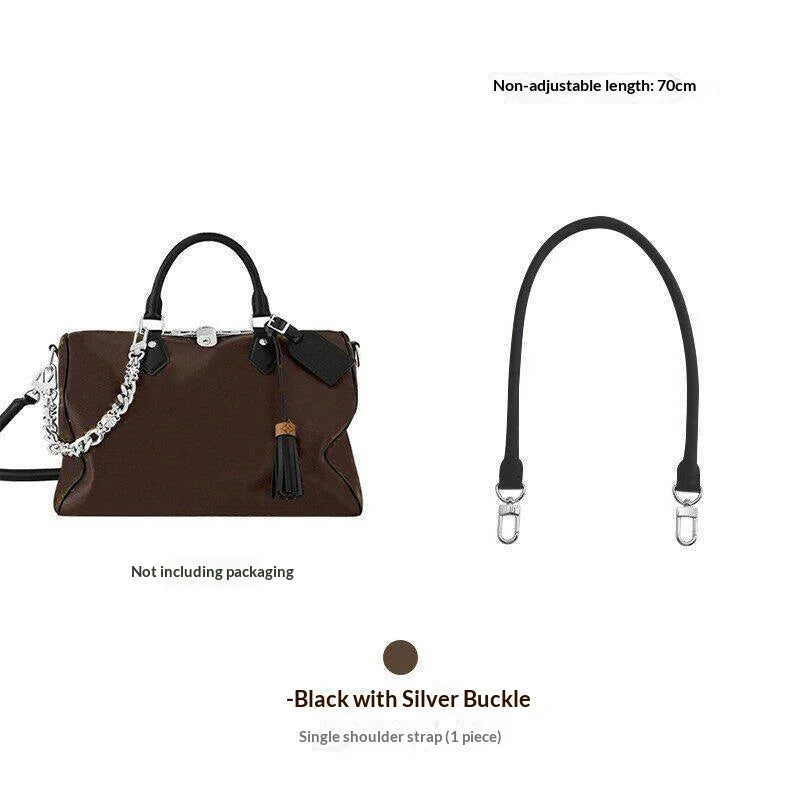 A black synthetic leather handbag with a silver buckle and a long strap is shown.