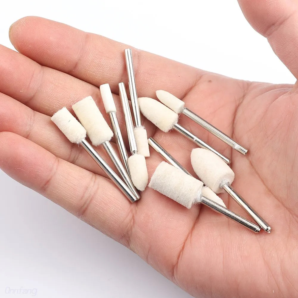 A hand holds several wool felt polishing wheels with metal shafts for rotary tools.