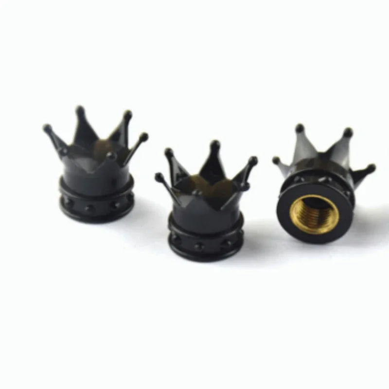 A set of four black universal crown valve caps for fluid connections.