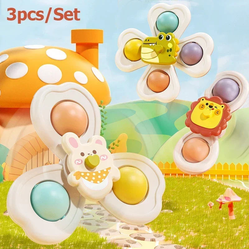 A set of three spinning bath toys featuring yellow and purple animals on a grassy background.