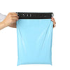 A hand is holding a light blue heavy-duty waterproof poly mailer bag with a black sealing strip.