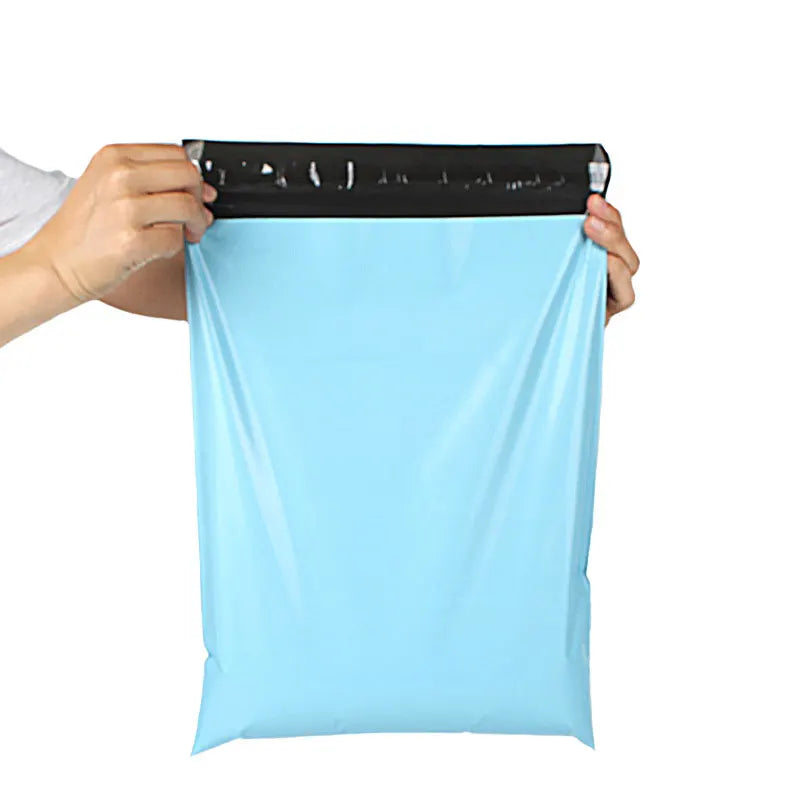 A hand is holding a light blue heavy-duty waterproof poly mailer bag with a black sealing strip.