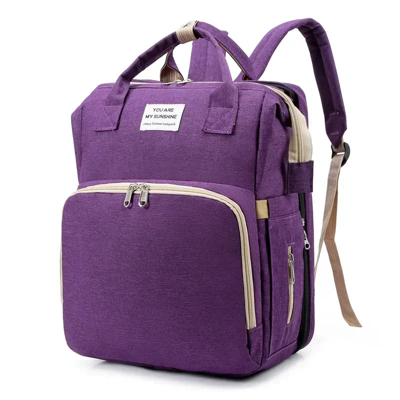 Purple large capacity diaper bag backpack with a beige changing mat visible.