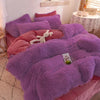A purple plush mink velvet duvet cover set with sheets featuring pink accents and a white stuffed animal.