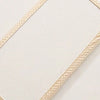 Housse de matelas moelleuse beige avec bord texturé, vue en diagonale.