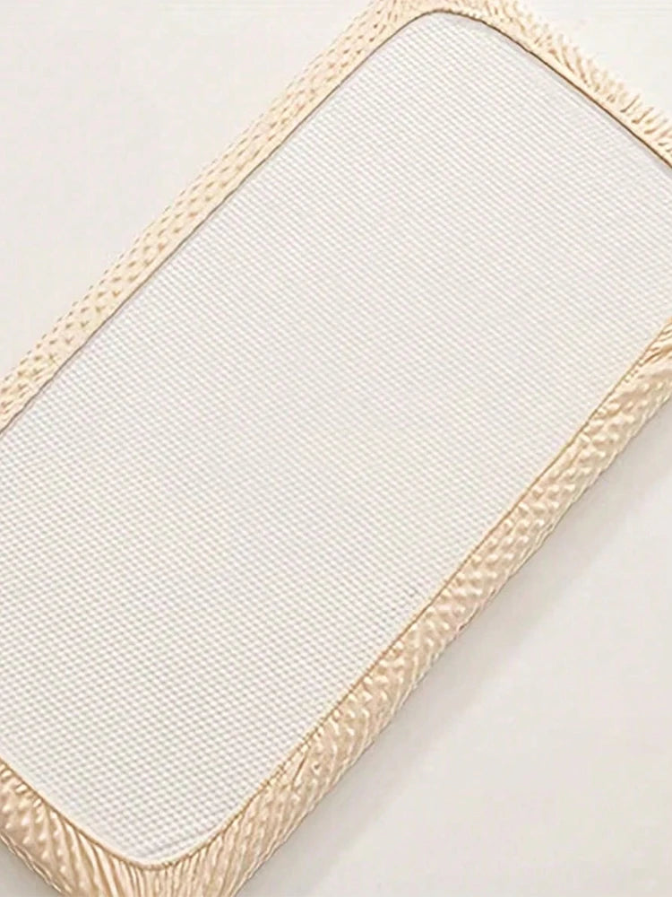 Housse de matelas moelleuse beige avec bord texturé, vue en diagonale.