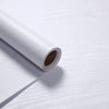 A roll of self-adhesive wood grain waterproof wallpaper lying on a white surface.