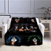 A black flannel throw blanket featuring a graphic print of the Kiss band members.