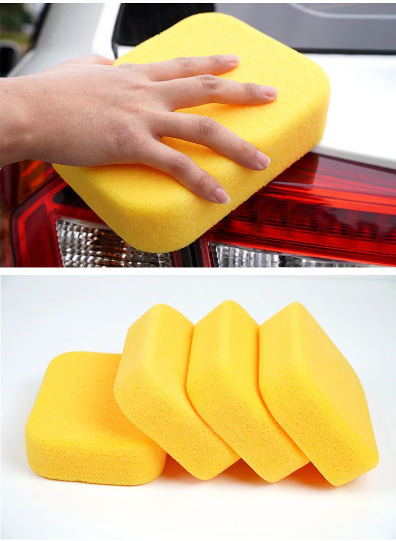 A hand is using a yellow high-density car wash sponge on a car's taillight, next to several yellow sponges.