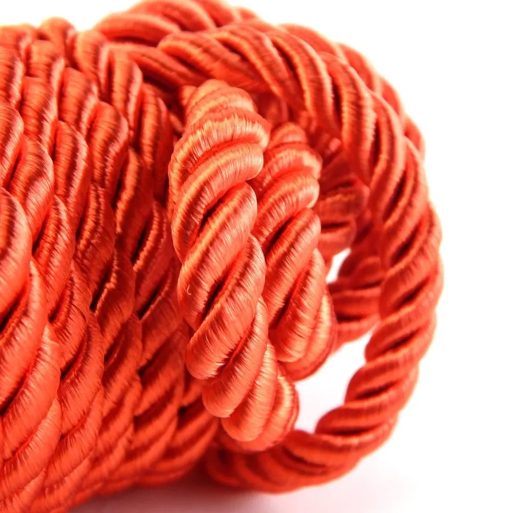 Coiled orange silk bondage rope used for couples roleplay