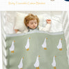 A soft, light green cotton blanket featuring a repeating pattern of white birds on a white background.