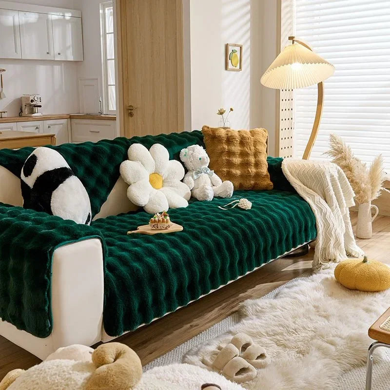Tiefgrüner Plüschhase-Sofa-Kissen mit weißen und beigen Kunstfellakzenten auf hellem Holzfußboden.
