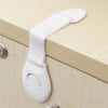 White multi-purpose baby safety strap attached to a cabinet drawer handle.