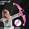A young girl is holding a pink light-up bow and arrow set with suction cups against a dark background.