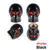 A set of four black skull design tire valve stem caps with red accents.