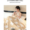 A woman is relaxing in bed with a beige plush jacquard throw blanket featuring white butterfly patterns.