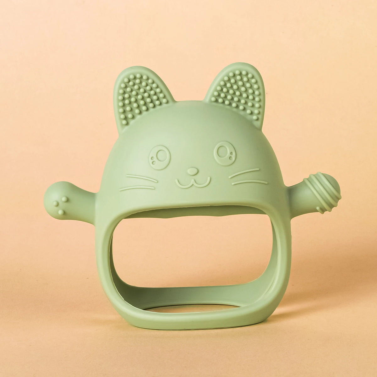 A light green silicone teether shaped like a cat's head with prominent ears and whiskers.