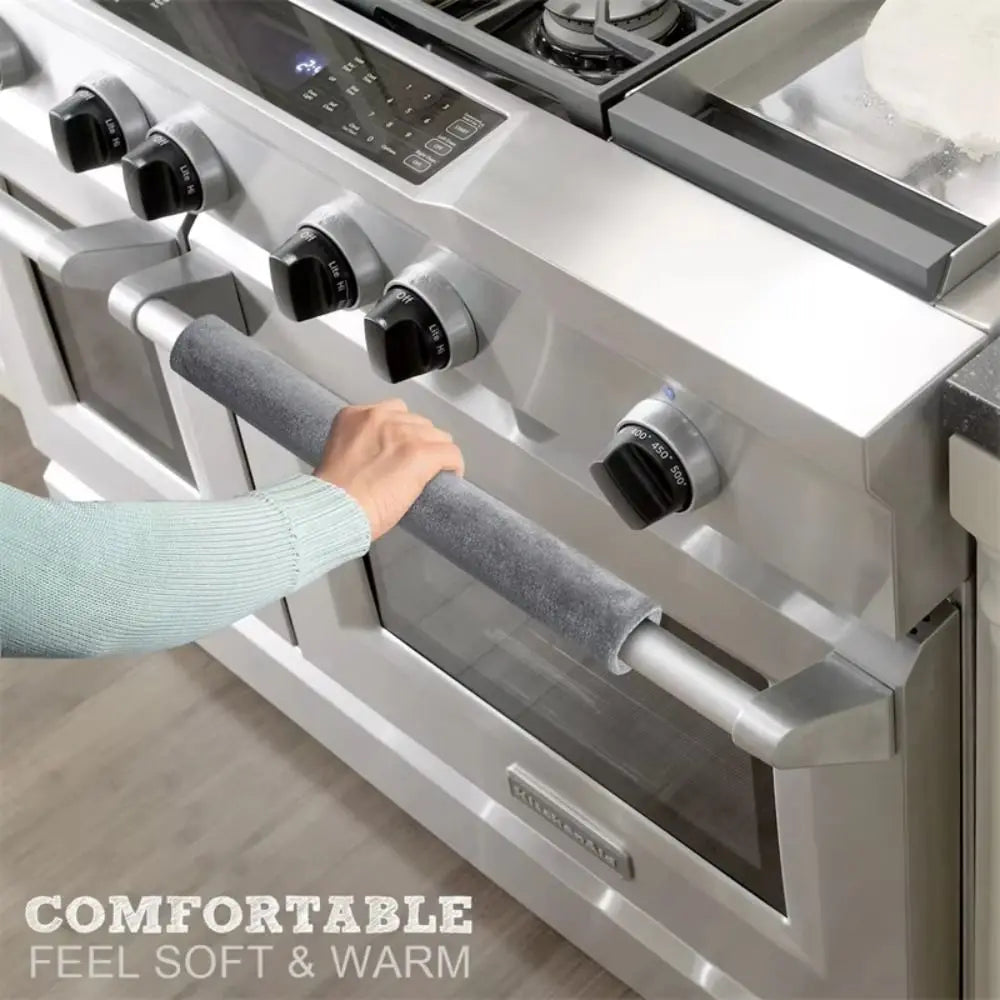 A hand is gripping a soft gray handle cover on a stainless steel appliance, emphasizing comfortable feel and warmth.