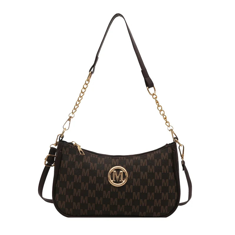 A black PU leather crossbody bag with a gold chain strap and a metal 'M' accent.