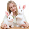 A young woman holds a white plush rabbit stuffed animal with pink ears.
