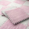 A square pink plush tile resting on a pink and white checkered rug.
