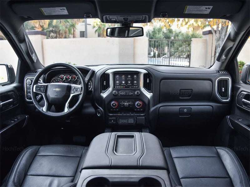 Interior view of a Chevrolet Silverado or GMC Sierra showing a custom fit dashboard cover installed.