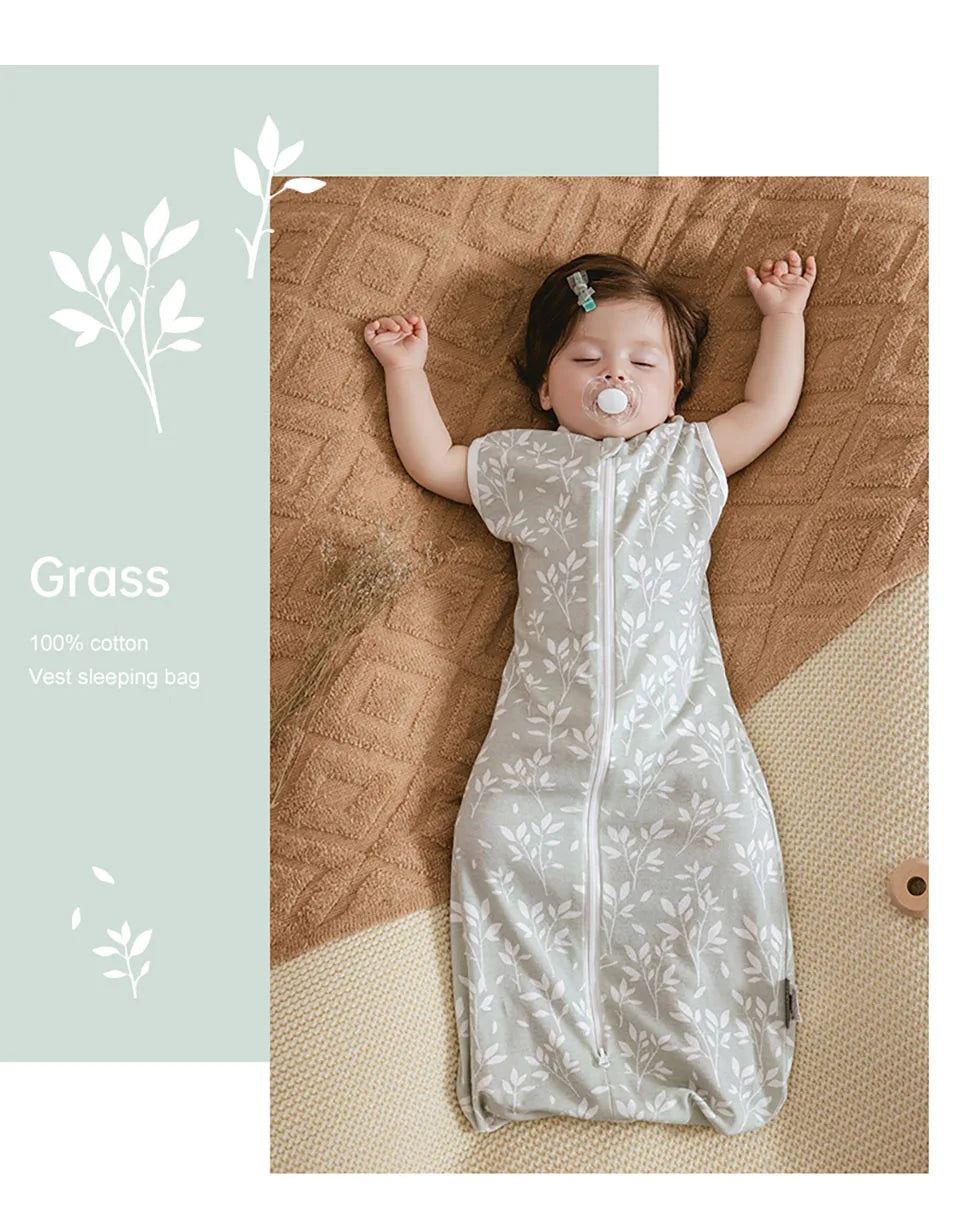 A baby wearing a light green and white patterned vest sleeping bag on a brown textured surface.