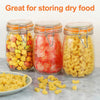 Three glass mason jars filled with dry food including fruit and pasta noodles