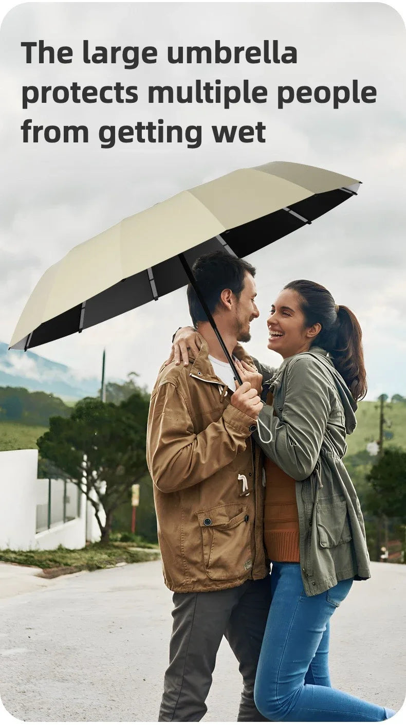 A couple walks outdoors under a large beige umbrella protecting them from the rain.