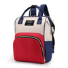 A beige and red insulated canvas mummy diaper bag with a blue accent and hanging hook.