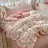 A pink floral duvet cover set with matching pillowcases and a flat sheet displayed on a bed.